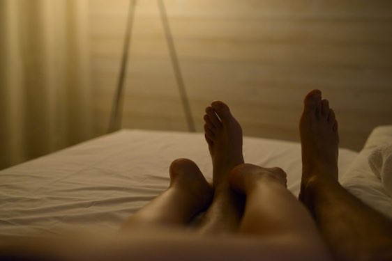 man and woman legs lying in bed.