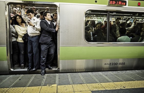 Tokyo, Japan - October 27, 2012: Passengers inside an overcrowded Yamanote Line train at rush hour in Tokyo Japan. Accounting the subway lines and all the other railways that operate in Tokyo 40 million people travel with this kind of transportation everyday in the city.