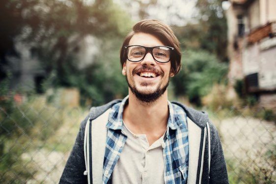 Outdoor portrait of a handsome young man with glasses.