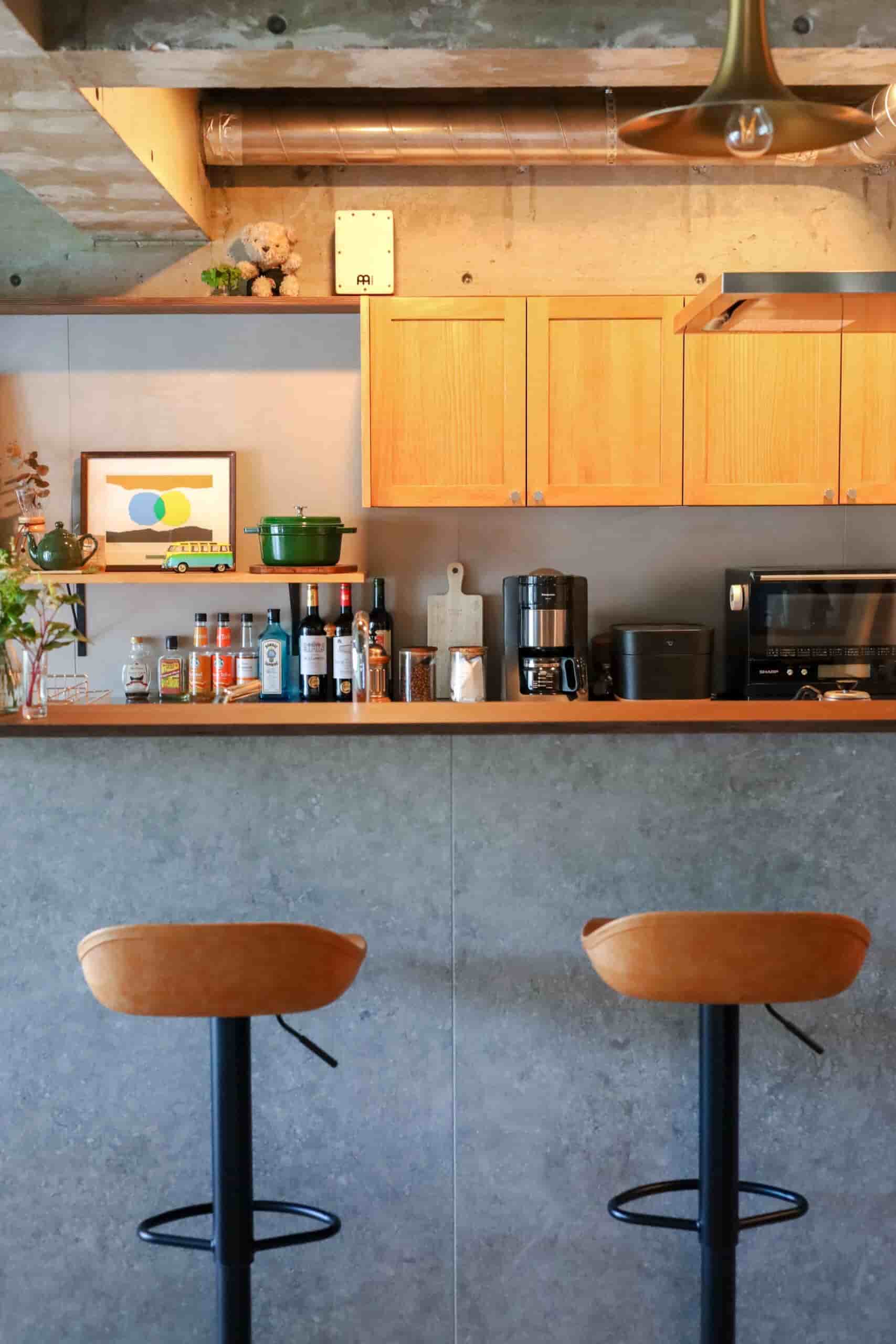 グレーの腰壁とウッディな天板のコントラストが印象的なキッチンカウンター
